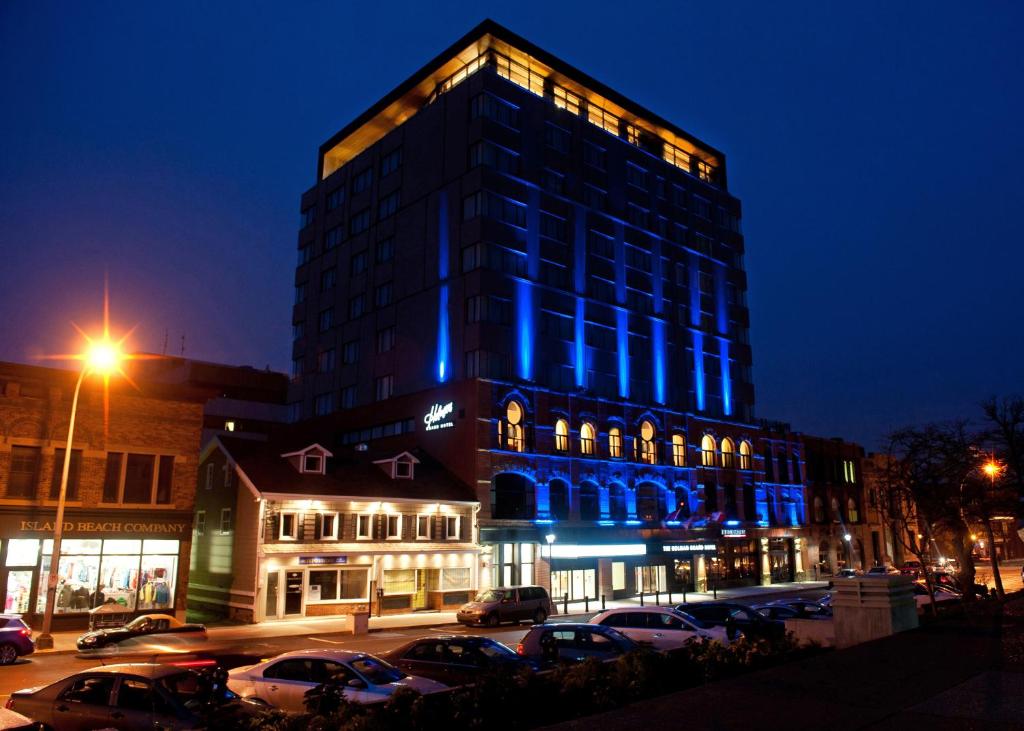 夏洛特顿霍尔曼大酒店 的一座高大的建筑,晚上有蓝色的灯光