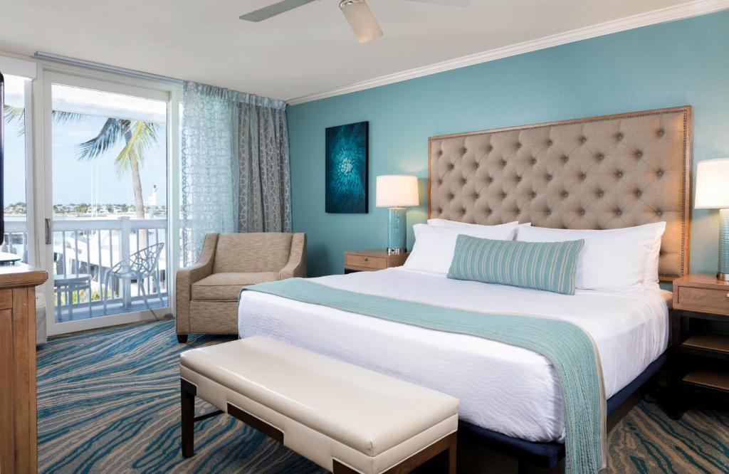 基韦斯特Opal Key Resort & Marina的卧室配有床、椅子和窗户。