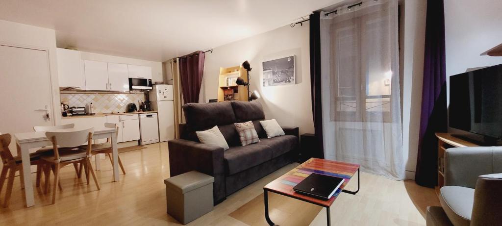 楠泰尔Duplex centre Ville的带沙发和桌子的客厅以及厨房。