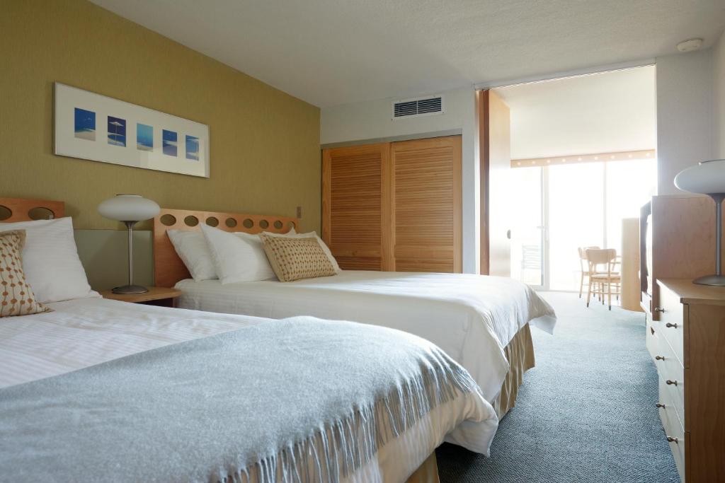 威尔伍德克拉斯特Pan American Oceanfront Hotel的酒店客房设有两张床和窗户。
