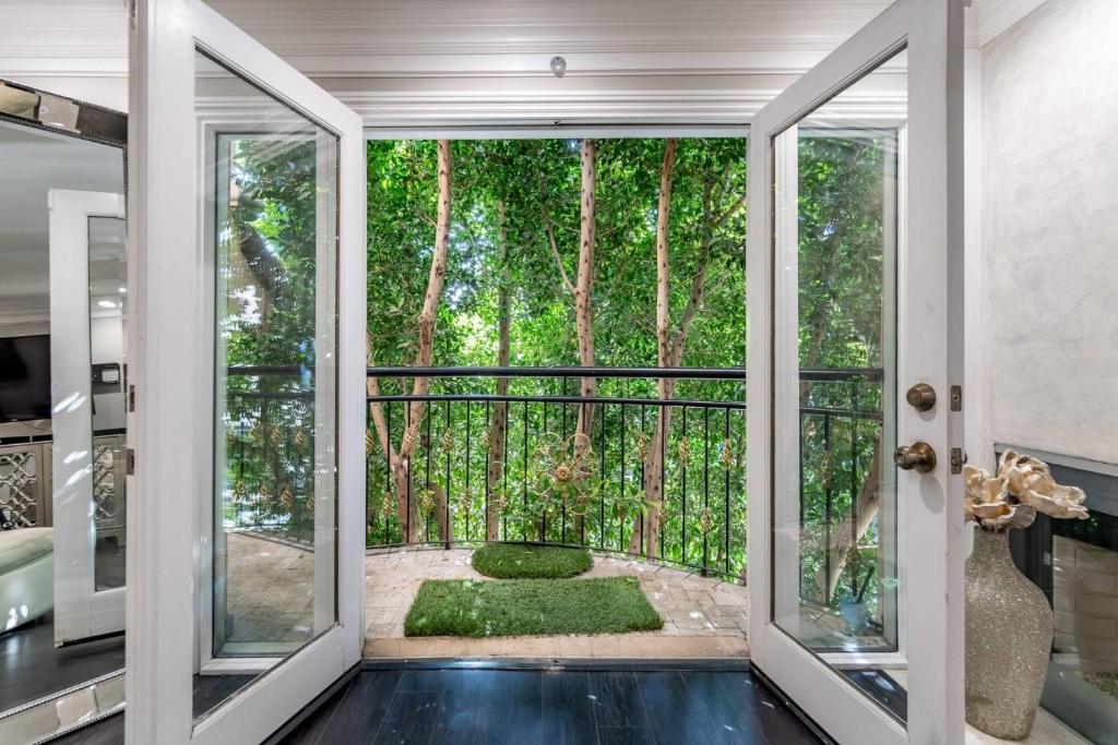 洛杉矶Barham Boutique Townhouse的一间设有门的客房,可通往树木繁茂的花园