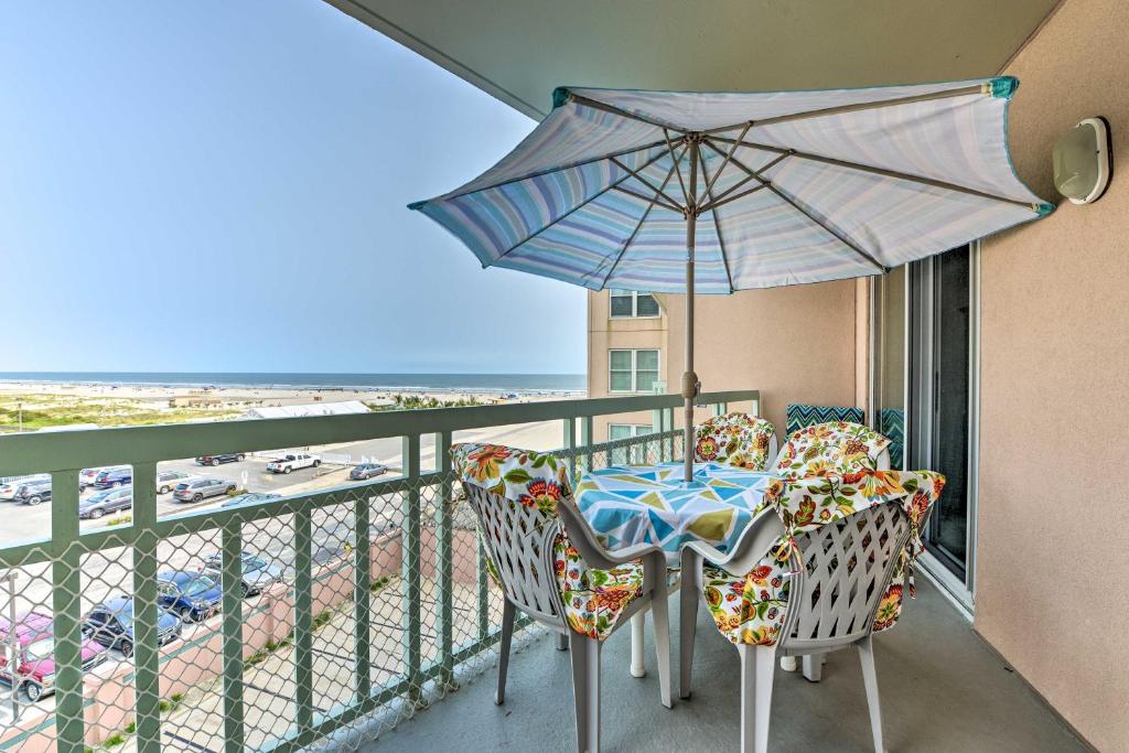 威尔伍德克拉斯特Oceanfront Resort, Year-Round Pools, Private Beach的阳台配有桌椅和遮阳伞。