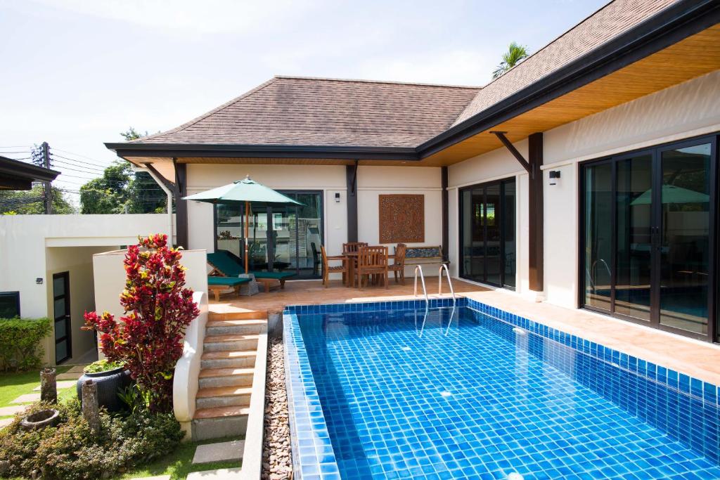 拉威海滩Foxtail Palm Villa的一座房子后院的游泳池