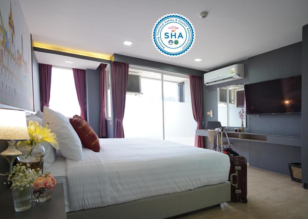 曼谷The Qube fifty Hotel的一间卧室设有一张大床和大窗户