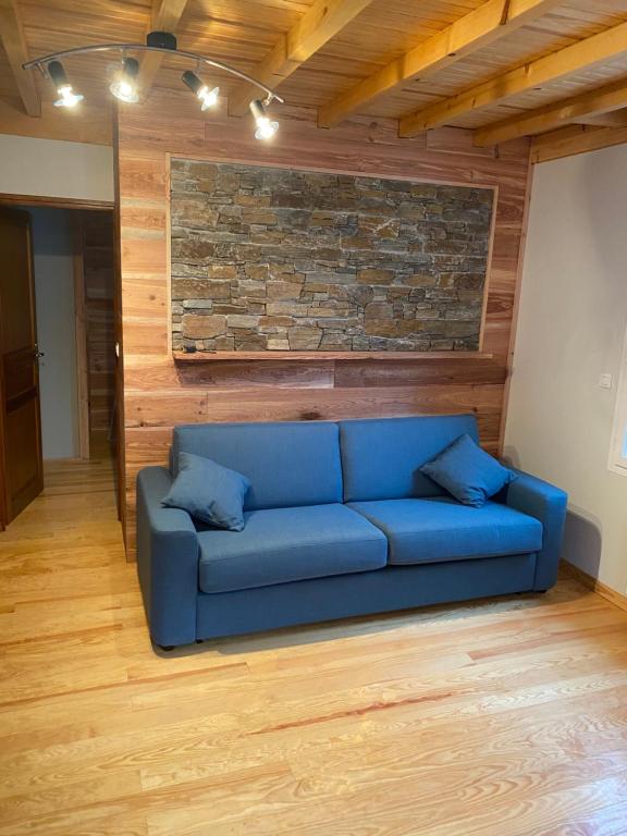 科特雷Appartement rénové 4pers tout confort & garage的砖墙间里一张蓝色的沙发