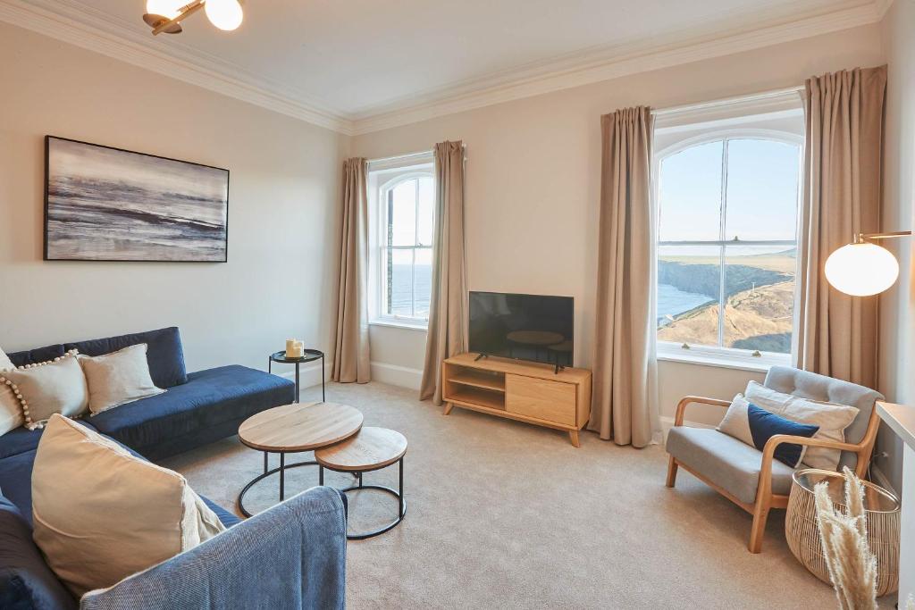 滨海索尔特本Host & Stay - Huntcliff View Apartment的客厅配有蓝色的沙发和电视