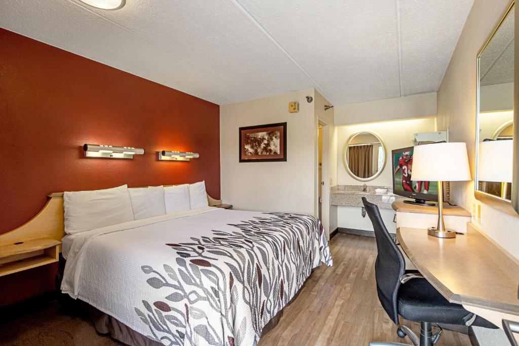 蔓越莓乡匹兹堡北克兰博瑞红屋顶客栈的配有一张床和一张书桌的酒店客房