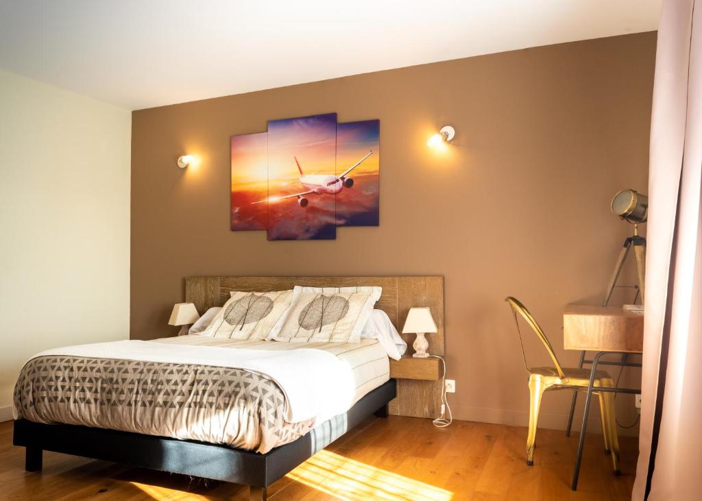 马里尼亚讷Escale villa的卧室配有一张床,墙上挂有绘画作品