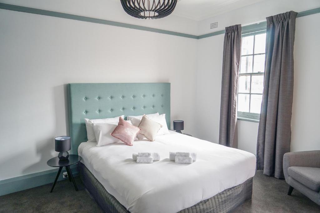 悉尼比米什绿洲酒店的卧室配有带粉红色枕头的大型白色床
