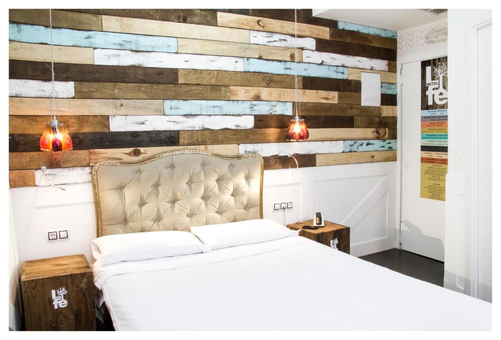马德里Hotel Life Gran Via Design的一间卧室设有一张床和木墙