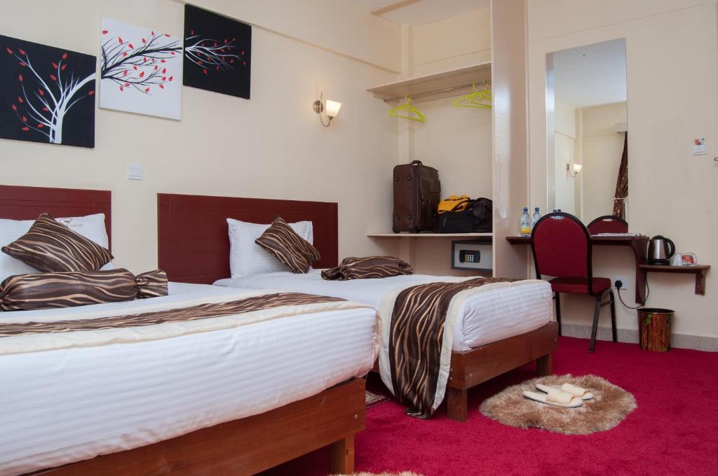 埃尔多雷特Merril Hotel的一间卧室配有两张床,铺有红地毯
