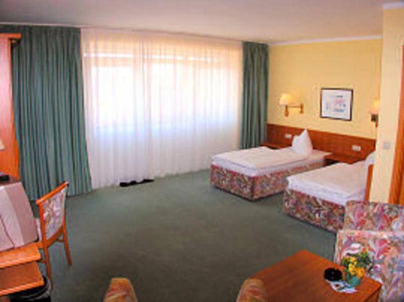 LankenTOP Motel Sassnitz的酒店客房设有两张床和一张桌子。