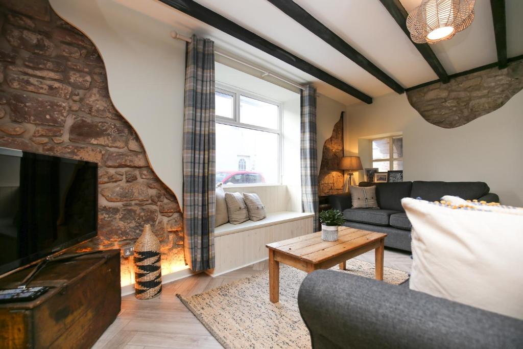 锡豪西斯Harbour Way Cottage的带沙发和壁炉的客厅