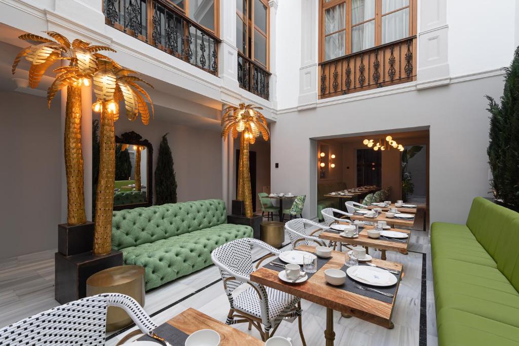 大加那利岛拉斯帕尔马斯Boutique Hotel Cordial Malteses的餐厅设有木桌和绿色椅子