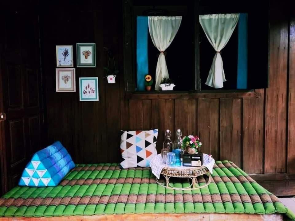 洛坤府Nakhon Si Ban Na Homestay的配有一张绿色床和桌子的房间