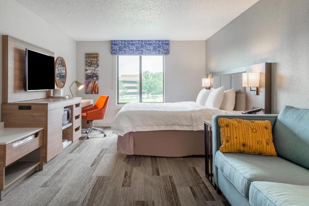 奥那拉斯加拉克罗斯/奥纳拉斯卡汉普顿酒店的酒店客房配有1张床、1台电视和1张沙发。