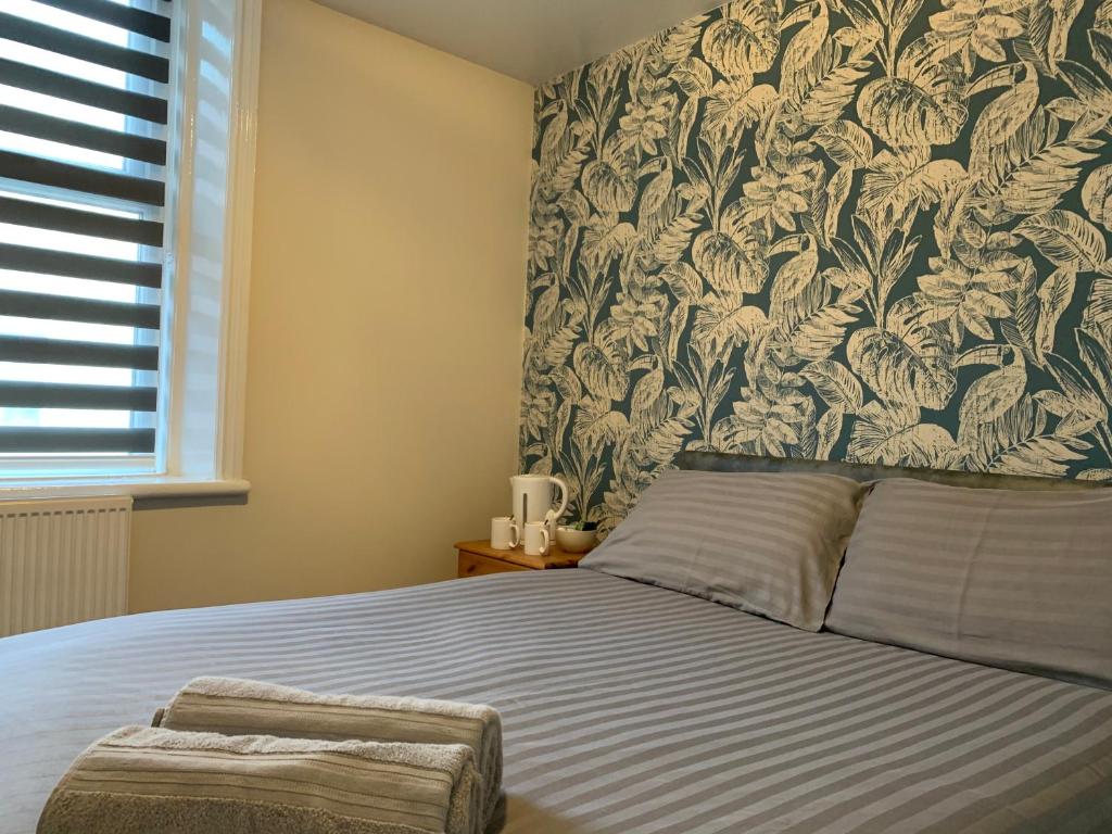 布莱克浦Malibu Hotel的一间卧室配有一张带花卉壁纸的床