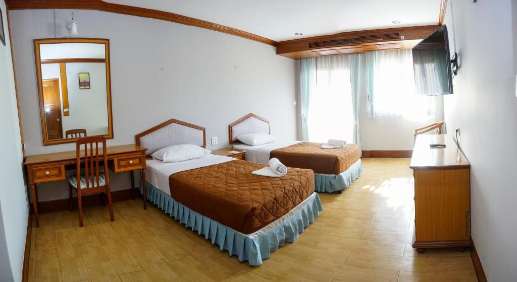 Ban Nong Bua Sangอุทยานบ้านเชียงเครือ的酒店客房,设有两张床和镜子