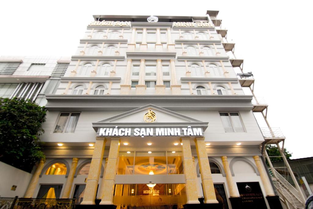 胡志明市Minh Tam Phu Nhuan Hotel & Spa的一座白色的大建筑,上面有标志