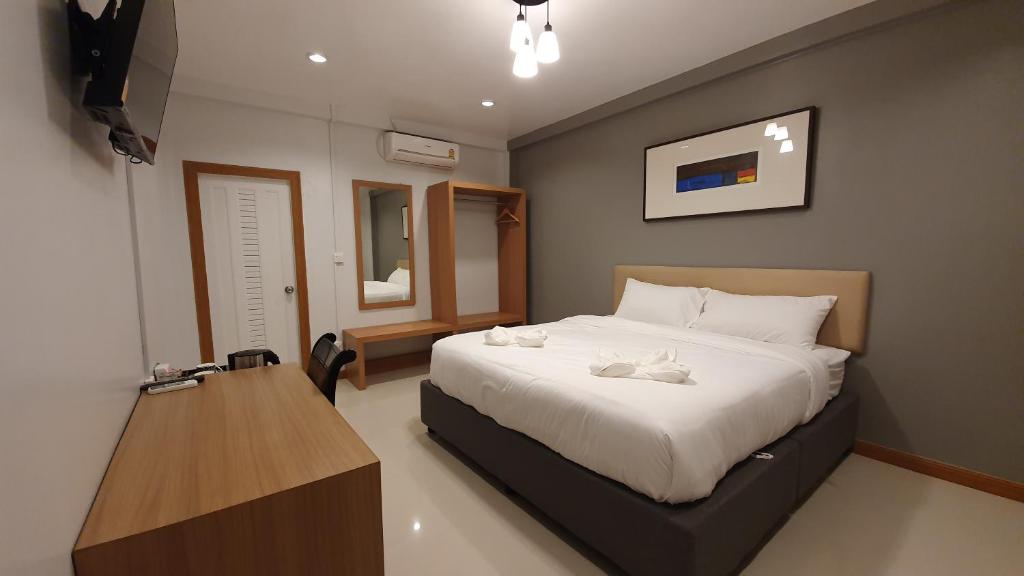 色军โรงแรมอินทราเพลส的一间卧室配有一张大床和一张木桌