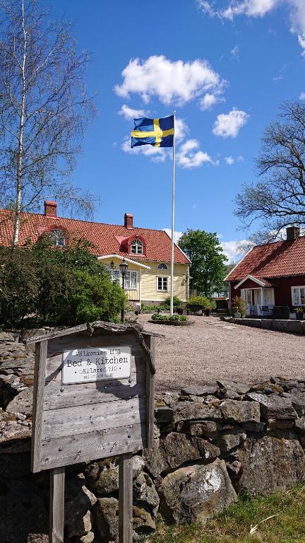 乌拉勒德Gällared 710 - Bed & Kitchen的悬挂在房子前面标志上的旗帜