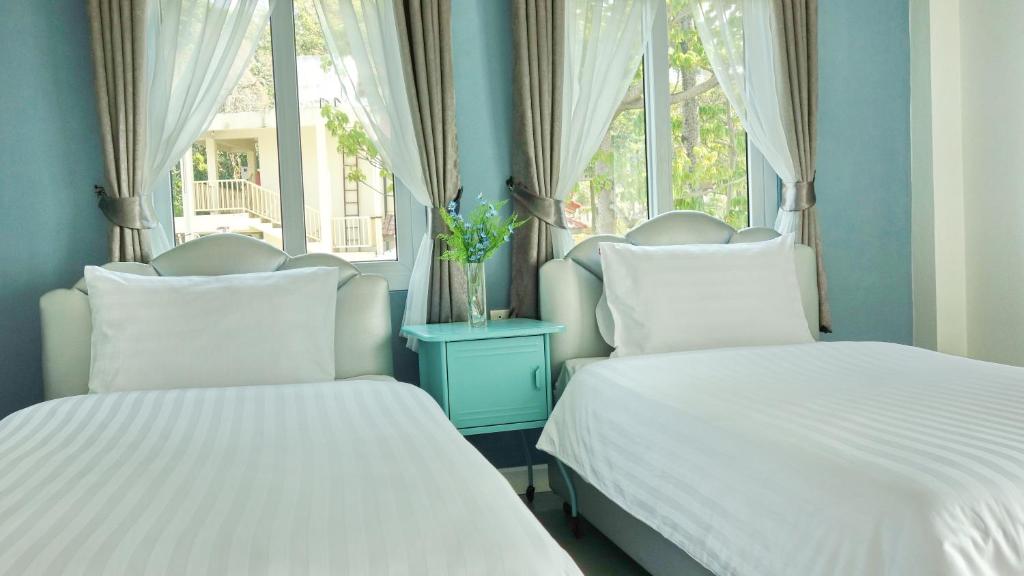 卡塔海滩Kata Bai D - SHA Certificate Hotel的带2扇窗户的客房内的2张床