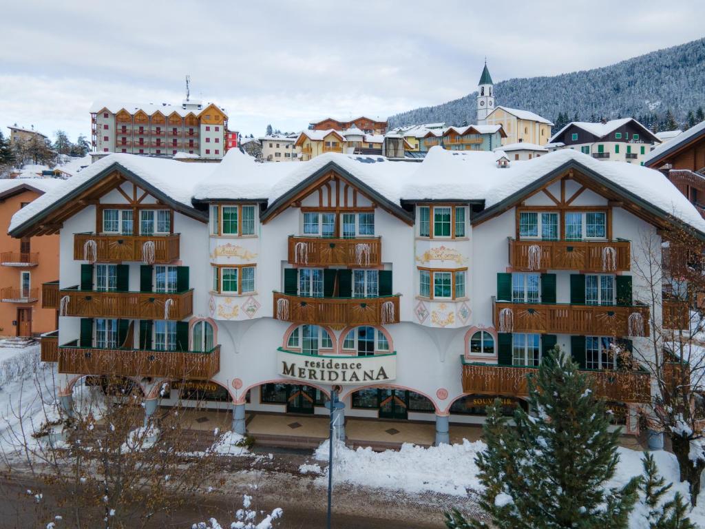 安达洛梅里迪安公寓式酒店的一座大建筑,屋顶上积雪