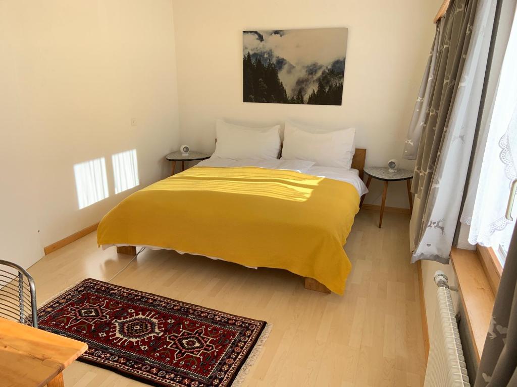 莱克斯Waldheim Pension Laax的一间卧室配有一张黄色毯子床