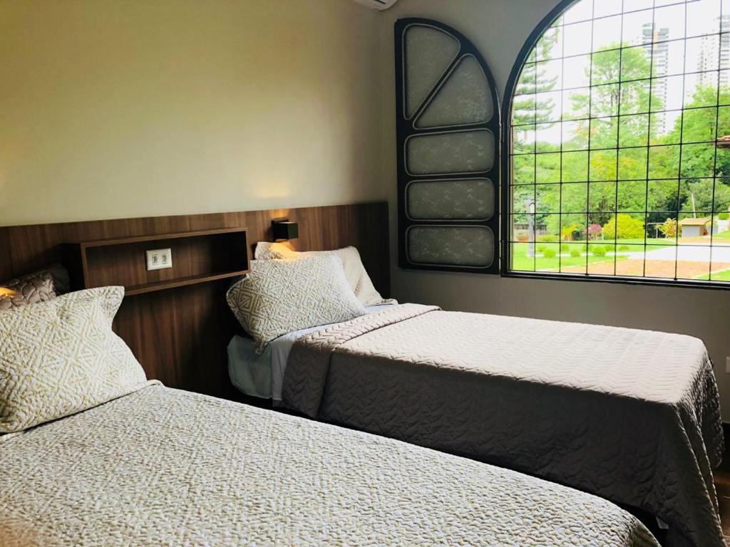 马林加Hostel SLG的一间卧室设有两张床和窗户。
