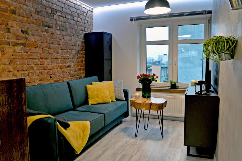 科希切日纳LOFT MAŁY的客厅设有蓝色的沙发和砖墙