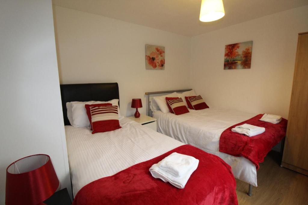 BolsoverBolsover House的一间卧室配有两张红色和白色床单