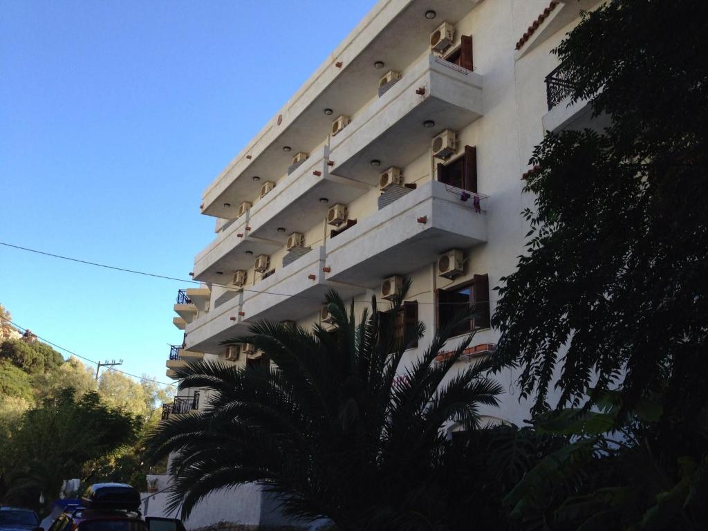 阿基奥斯基利考斯奥伊诺伊旅馆的带阳台的建筑,前面有棕榈树