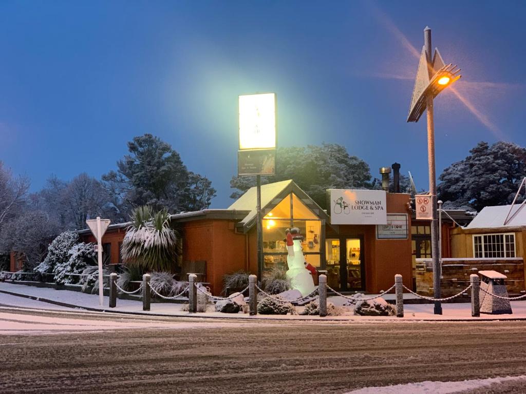 奥阿库尼Snowman Lodge and Spa的风车前有雪人的小店