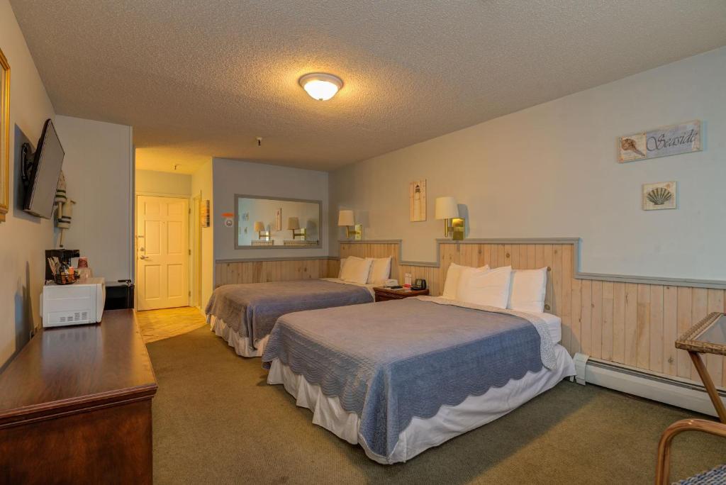 BrewerVacationland Inn & Suites的酒店客房设有两张床和电视。