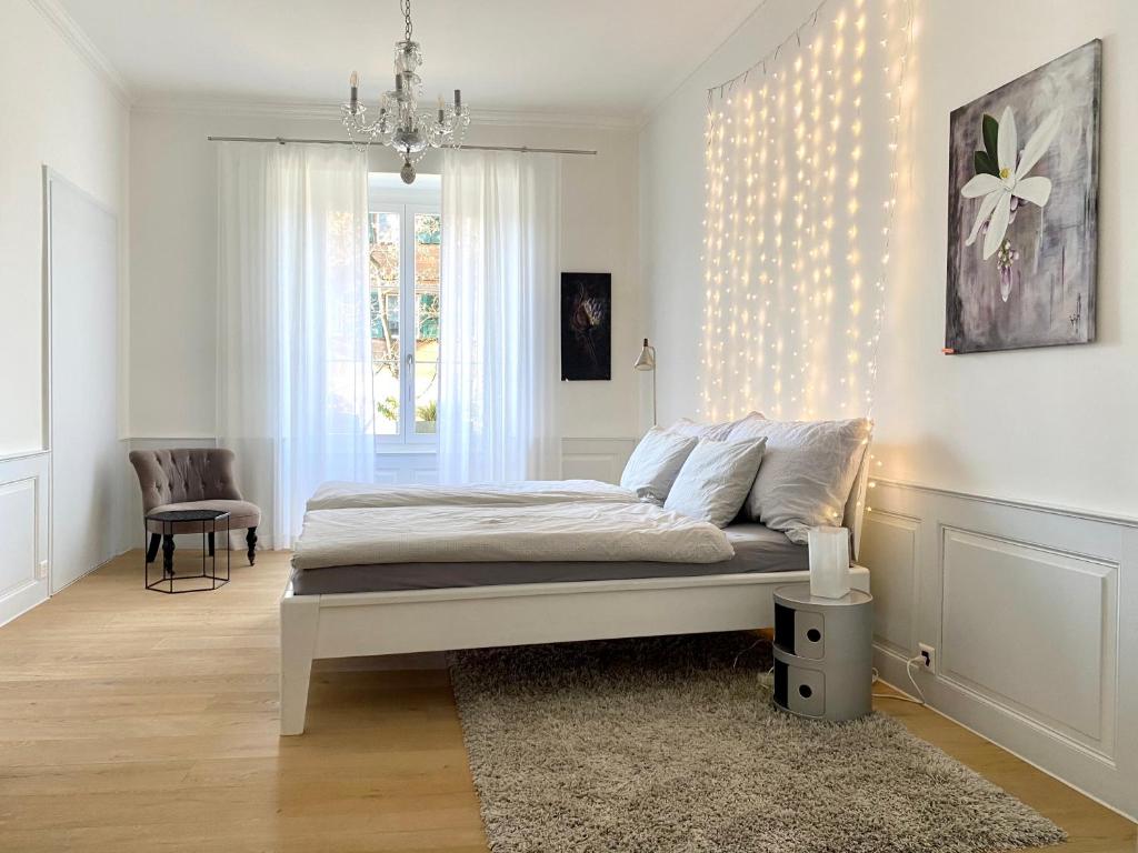 图恩Beautiful studio in a villa from 18th century的白色卧室配有一张床和一个吊灯