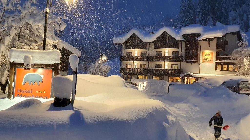 摩德纳迪-坎皮格里奥蒙塔纳酒店的站在酒店前雪中的人