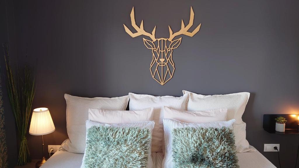 内尔哈Carmen Rooms -- Boutique B&B by the sea的卧室配有一张带鹿头的墙壁床。