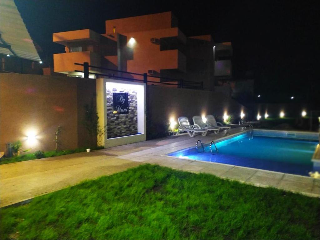 坦季By Muni Apartamentos Premium的一座游泳池,在晚上在建筑物前