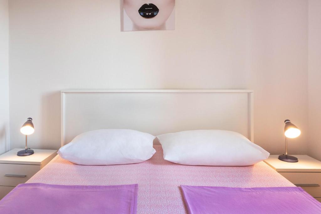 亚德里亚Apartment Marin的床上配有2个白色枕头和2盏灯