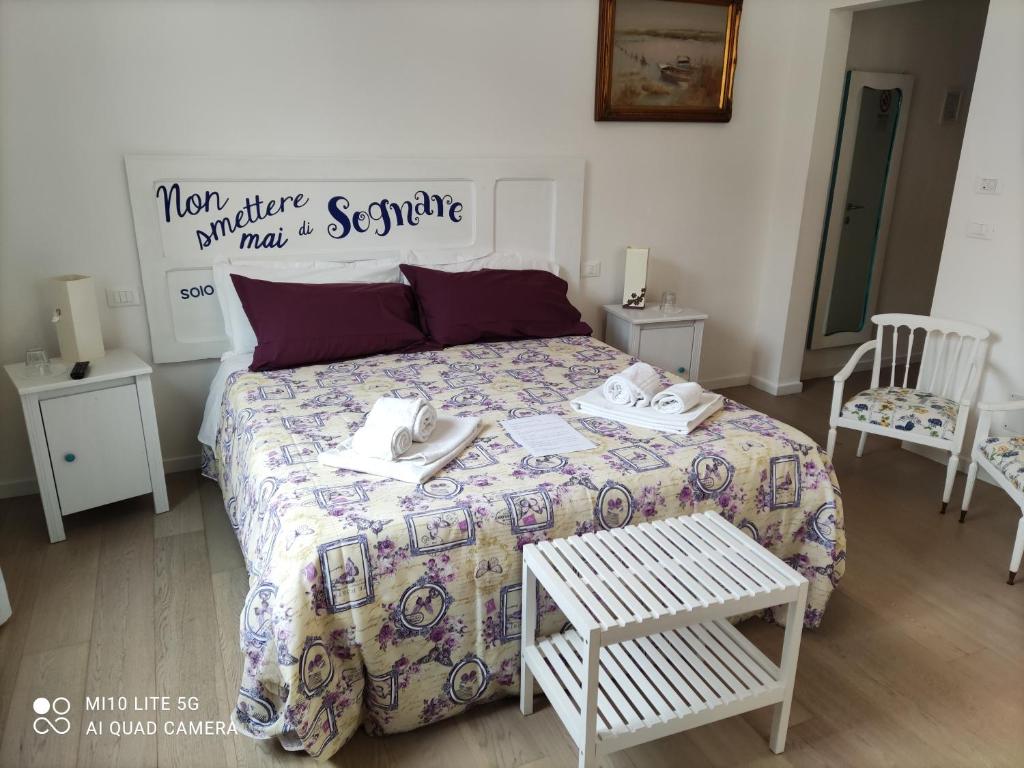 博洛尼亚拉莫罗索蒂帕奥罗纳塔里尼酒店的一间卧室配有一张带被子的床和两把椅子