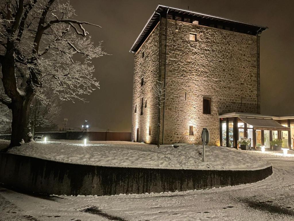 奥尼亚特托雷祖迈泰利酒店的一座大砖砌的建筑,地面上积雪