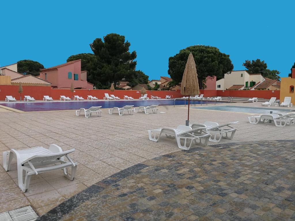 滨海阿热莱斯Vacargeles casa Les Mûriers et Les Chênes verts calme clim wifi animations piscine mini golf的一组白色椅子和一个游泳池