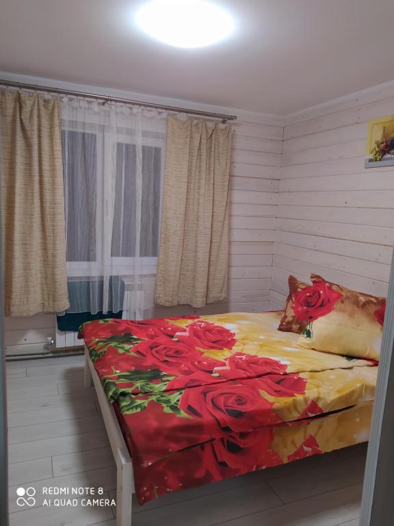 斯拉夫西克Good House的一间卧室,床上有红色的鲜花