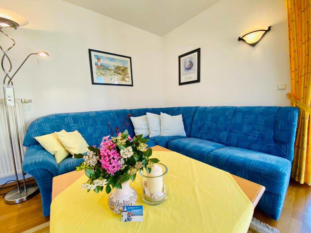 黑灵斯多夫Residenz Bleichröder - Ferienwohnung 27的客厅配有蓝色的沙发和带鲜花的桌子