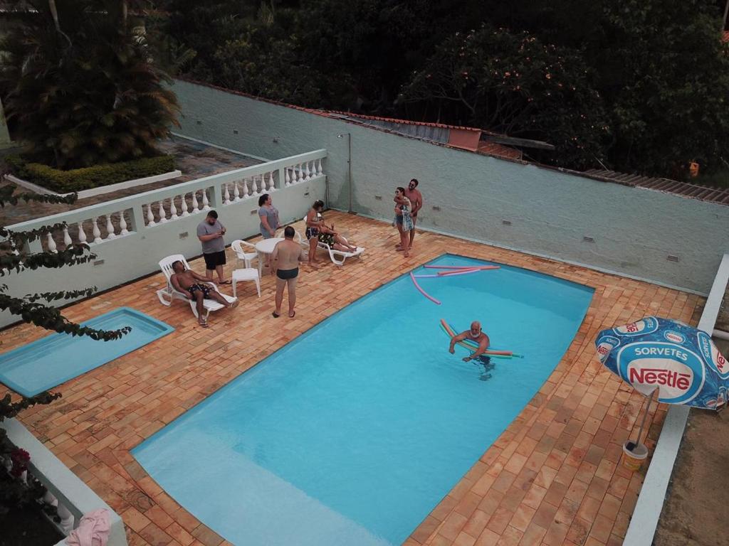 迈林克Linda Chácara com Piscina Churrasqueira e Wi-FI的一群人站在游泳池周围