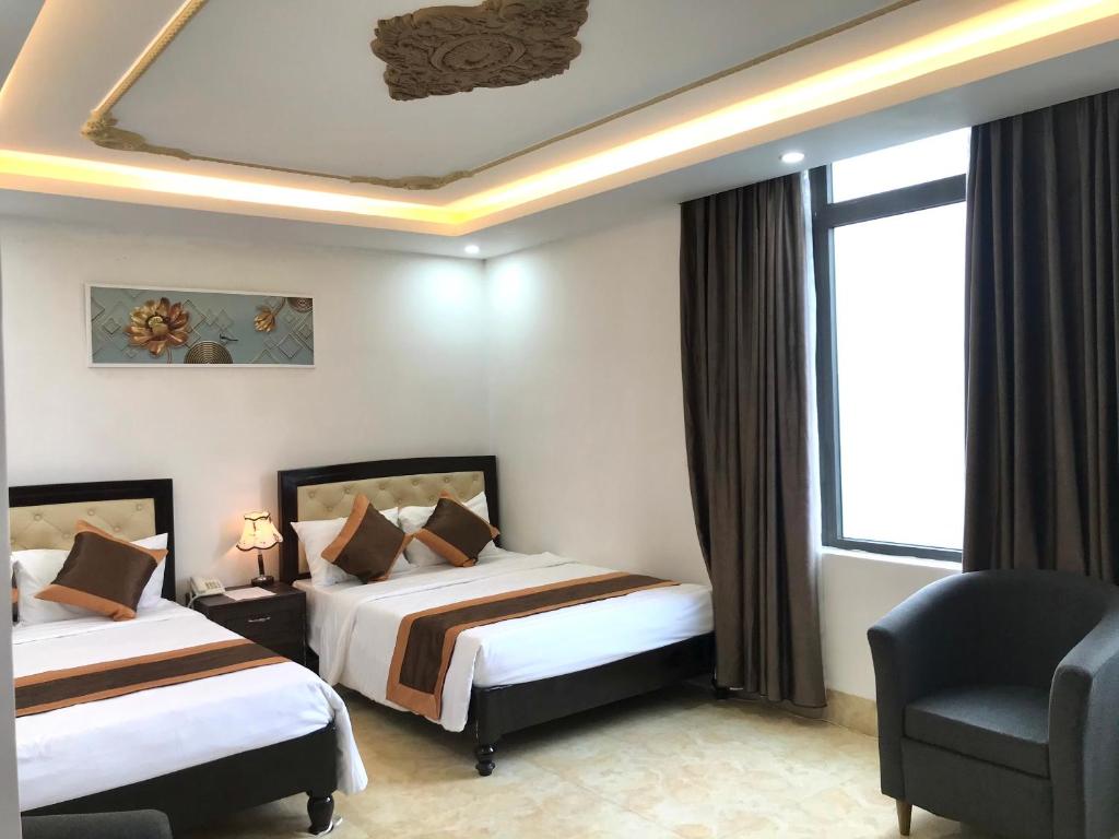 顺化THẢO AN HOTEL Huế的酒店客房,配有两张床和椅子