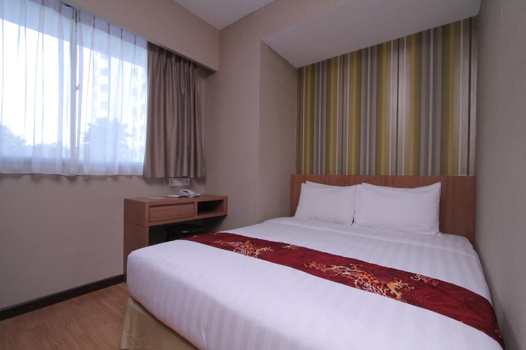 哥打京那巴鲁Likas Square - KK Apartment Suite的一间设有大床和窗户的酒店客房