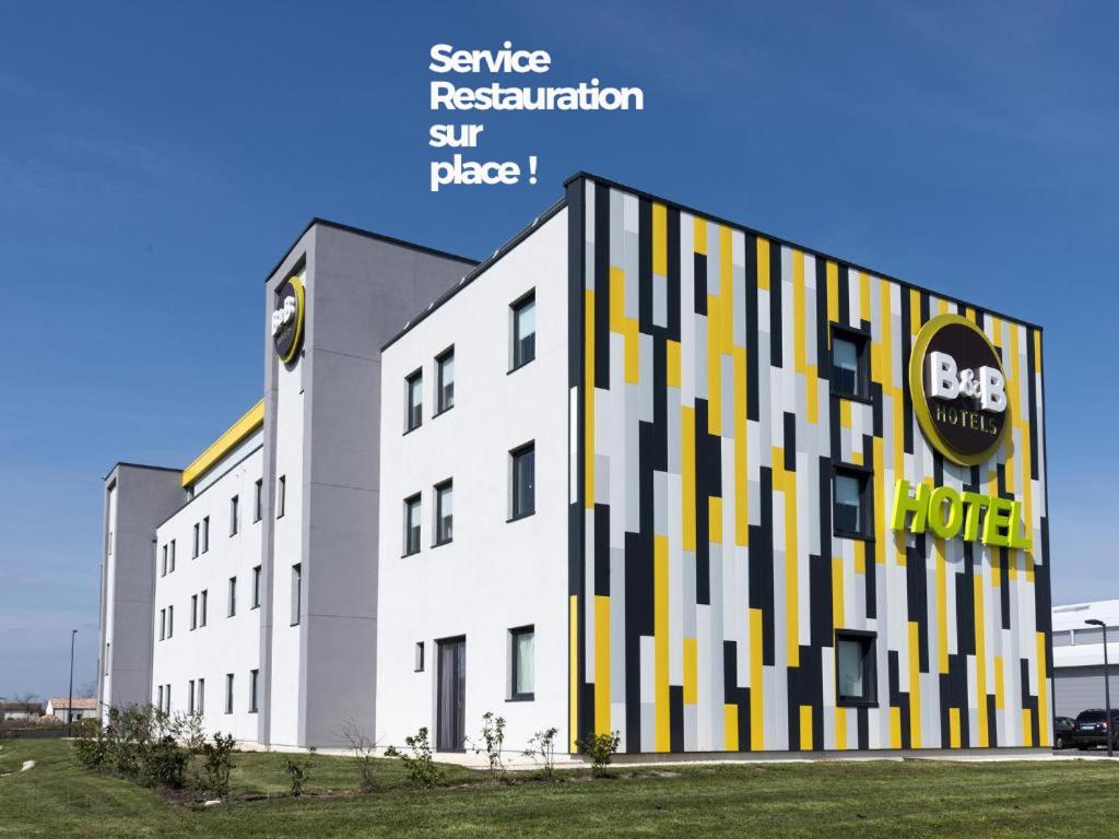 尼奥尔B&B HOTEL Niort Marais Poitevin的黑色和黄色外墙的白色大建筑