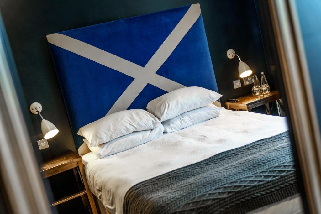 哈罗盖特The Castle Inn的一间卧室配有一张带蓝色床头板和枕头的床。