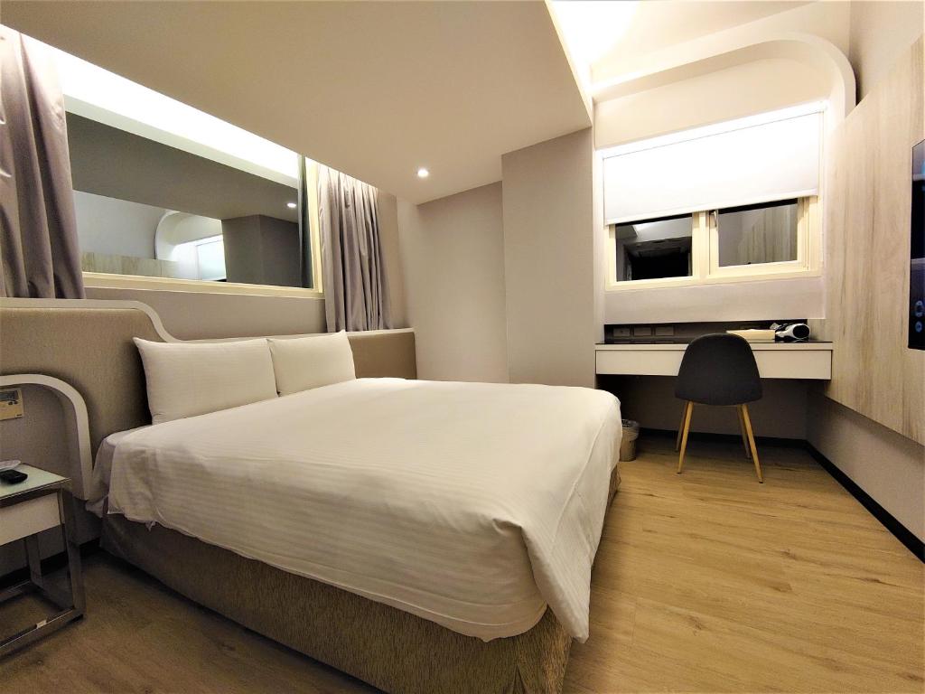 台北旅居文旅-西门驿站的一间卧室配有一张床、一张书桌和一个窗户。